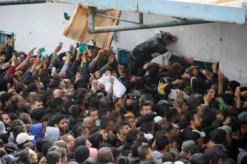 Para penduduk berkumpul beramai-ramai bagi mendapatkan bantuan di gudang Agensi Bantuan dan Kerja Menyelamat Pertubuhan Bangsa-Bangsa Bersatu (PBB) bagi pelarian Palestin (UNRWA) di Gaza.