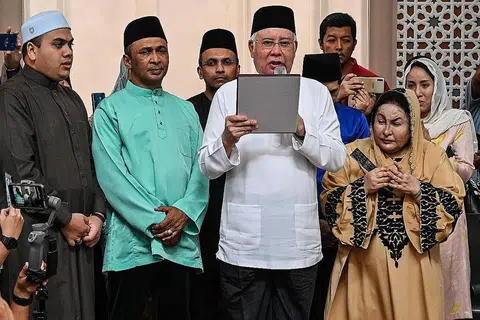 NAFI TERBABIT: Datuk Najib (dua dari kanan) mengangkat 'sumpah laknat' sambil diperhatikan isterinya Datin Rosmah (kanan) di Masjid Jamek di Kampung Baru selepas solat Jumaat semalam. - Foto AFP