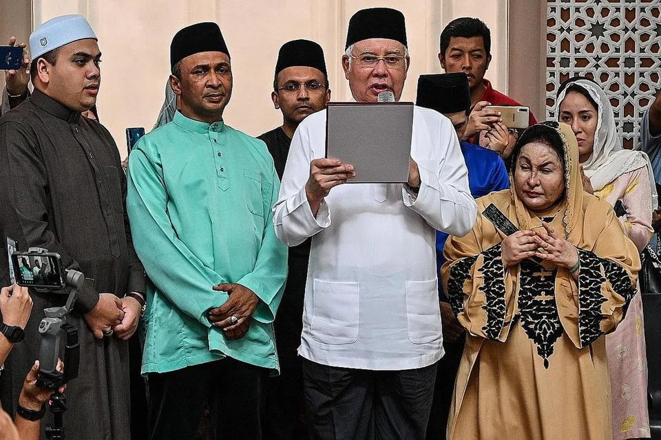 NAFI TERBABIT: Datuk Najib (dua dari kanan) mengangkat 'sumpah laknat' sambil diperhatikan isterinya Datin Rosmah (kanan) di Masjid Jamek di Kampung Baru selepas solat Jumaat semalam. - Foto AFP