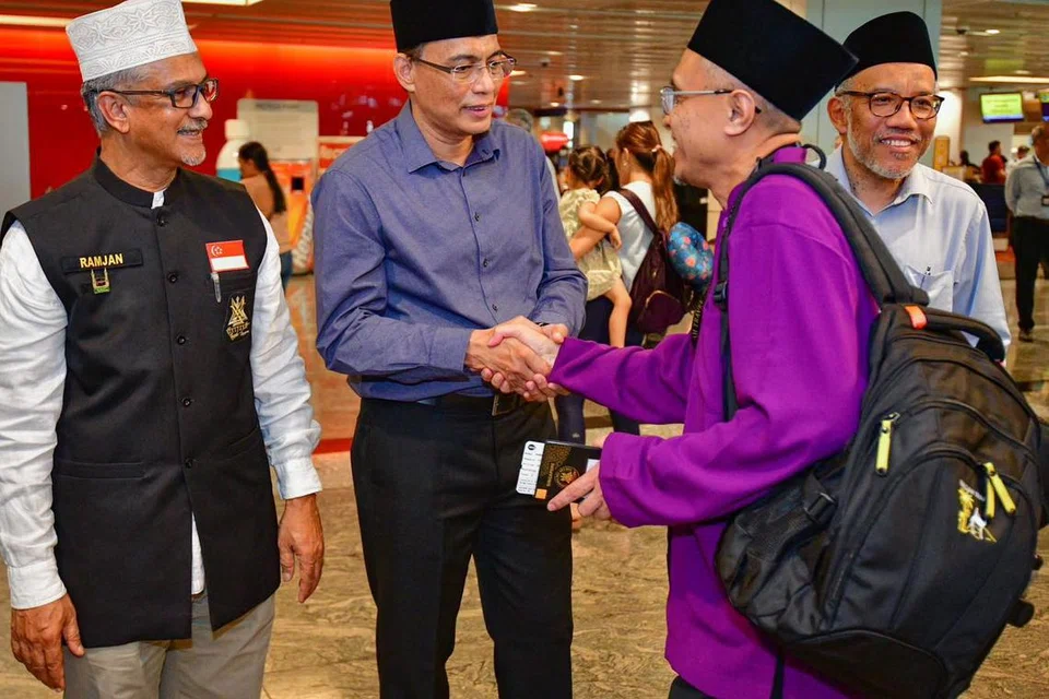 UCAP SELAMAT JALAN: Ketua pegawai eksekutif Majlis Ugama Islam Singapura, Encik Kadir Maideen (dua dari kiri), berjabat tangan dengan salah seorang jemaah haji sebelum keberangkatan ke Tanah Suci.