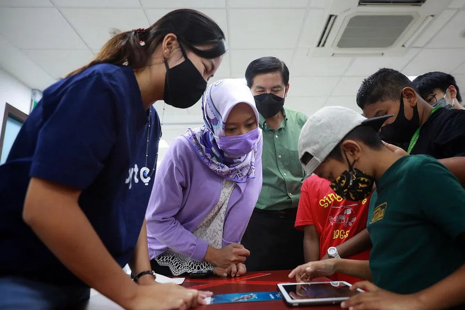 CELIK DIGITAL: Cik Rahayu (dua dari kiri) bersama Anggota Parlimen bagi GRC West Coast Encik Ang Wei Neng (tiga dari kiri, baju hijau) menyaksikan Asyraf (paling kanan) melakukan aktiviti dalam talian di bengkel celik digital di Kelab Masyarakat Nanyang kelmarin. - Foto BH oleh JASON QUAH