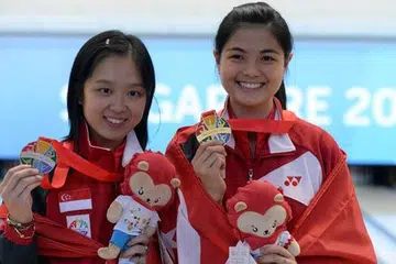 RATU BOWLING: Jazreel Tan (kiri) dan Daphne Tan bergambar bersama pingat mereka. - Foto-foto THE STRAITS TIMES