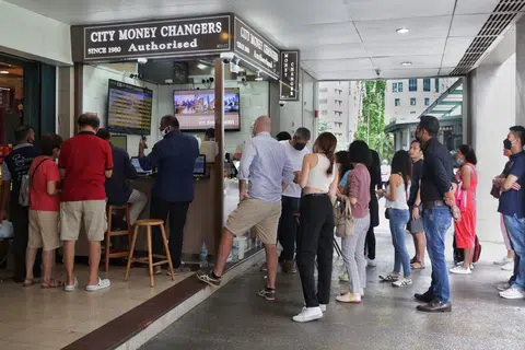 BERATUR TUKAR WANG: Ramai orang beratur di gerai pengurup Citi Money Changers di The Arcade untuk menukar wang asing, termasuk ringgit yang turun ke paras rendah berbanding dolar Singapura.
