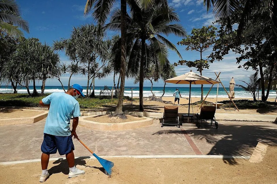 SEDIA TERIMA PELANCONG: Seorang pekerja sedang membersihkan satu kawasan berdekatan pantai di Phuket sedang pulau itu bersedia dibuka semula kepada pelancong yang telah diberi vaksinasi sepenuhnya mulai 1 Julai. - Foto REUTERS