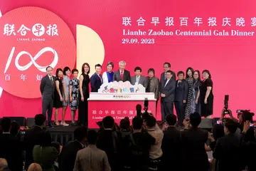 SAMBUTAN SEABAD: Perdana Menteri Lee Hsien Loong  (bertali leher merah) diapit Ketua Editor Kumpulan Media Cina SMT, Cik Lee Huay Leng (kanannya), dan Pengerusi SMT, Encik Khaw Boon Wan (kirinya), Editor Lianhe Zaobao ,Encik Goh Sin Teck (enam dari kiri), dan Ketua Pegawai Eksekutif SMT, Cik Teo Lay Lim (sebelah Encik Khaw),  bergambar sama di sambutan 100 tahun Zaobao pada Jumaat.