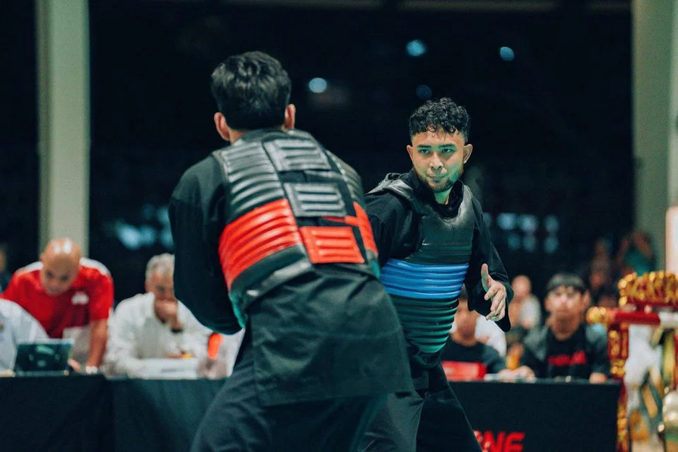 PERJUANGAN TERAKHIR:  Pesilat dari Universiti Teknologi Nanyang (NTU), Muhammad Fikri Fazil (biru) menamatkan penyertaannya dalam pertandingan Kejohanan Silat Antara Institusi Pengajian Tinggi (TSC) dengan pingat emas. 
