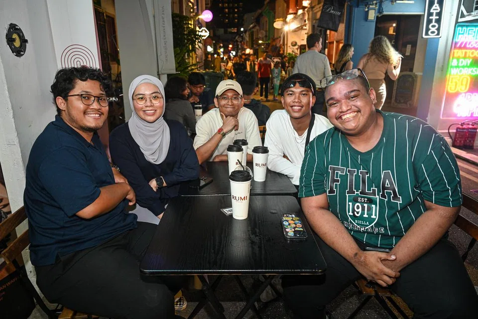 (Dari kiri) Encik Muhammad Zikry Razmi, Cik Adlyna Adly dan rakannya yang tidak mahu dinamakan (tengah), bersama Encik Ihsan Ramdan Abdul Rashid dan Encik Muhammad Aqasha Johari di tempat duduk luar Rumi The Poet’s Cup. 