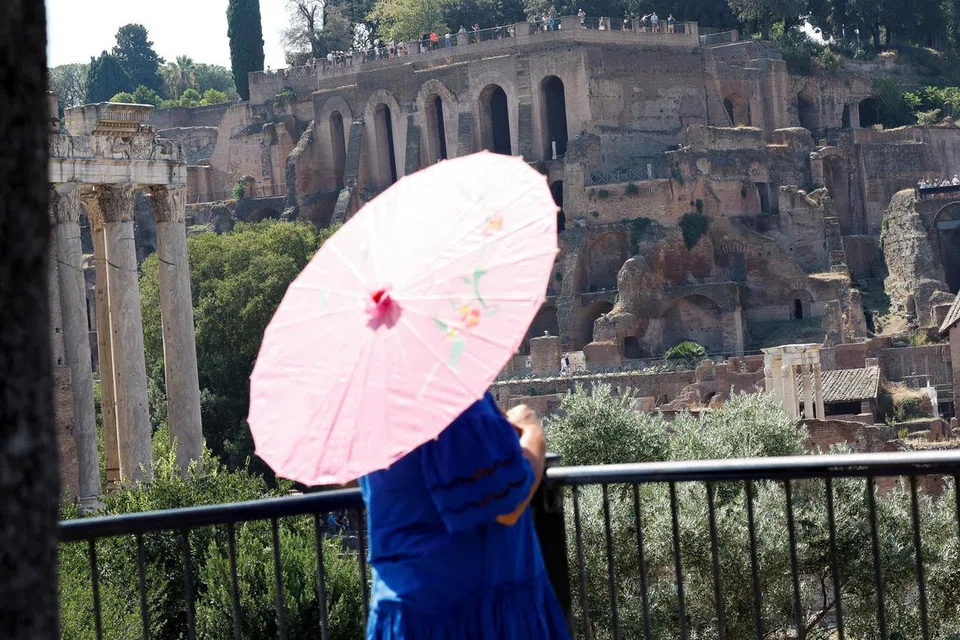 CEGAH SINARAN UV: Membawa payung untuk melindungi kulit daripada sinaran UV atau hujan ketika melancong sangat membantu biarpun ia kurang popular.