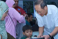 Menteri Tenaga Manusia, Dr Tan See Leng, yang juga Anggota Parlimen GRC Marine Parade, mengedarkan kotak bento kepada penduduk di acara berbuka puasa di Blok 44A Marine Crescent pada 8 Mac. 