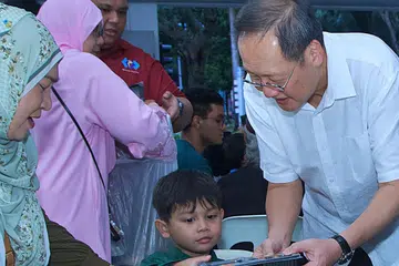 Menteri Tenaga Manusia, Dr Tan See Leng, yang juga Anggota Parlimen GRC Marine Parade, mengedarkan kotak bento kepada penduduk di acara berbuka puasa di Blok 44A Marine Crescent pada 8 Mac. 