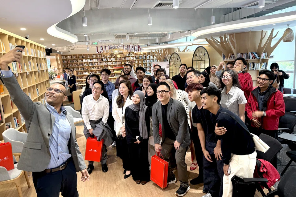 Ketua Pegawai Eksekutif Mendaki, Encik Mohamed Feroz Mohamed Akber (depan), bergambar bersama para pelajar dan pemain industri selepas sesi dialog di China-Singapore Smart Park.