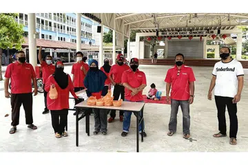 PENGAGIHAN BUBUR DI KEJIRANAN YISHUN: Sukarelawan dari Jawatankuasa Eksekutif Kegiatan Melayu (MAEC) Nee Soon East membantu dalam agihan bubur Ramadan di hadapan Blok 293 Yishun Street 22. - Foto MASJID DARUL MAKMUR
