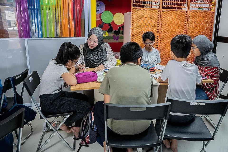 BIMBING PELAJAR: Cik Hidayah Ismail (dua dari kiri) membimbing kanak-kanak di pusat tuisyen miliknya, Genius Young Minds (GYM). Beliau kini mempunyai empat cawangan di serata Singapura. - Foto BM oleh NUR DIYANA TAHA