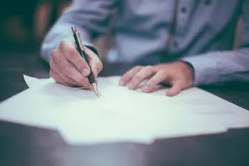 Gambaran seorang yang sedang menulis.
