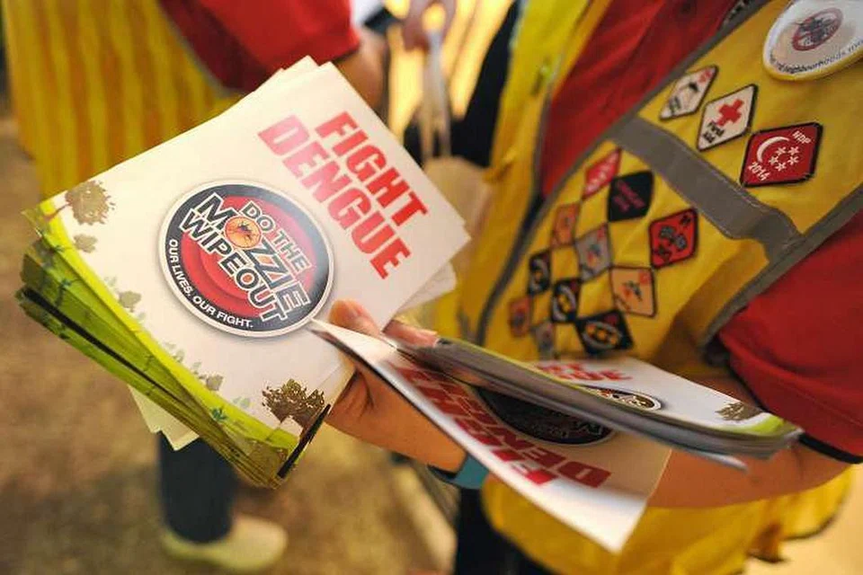 Sukarelawan mengedarkan risalah pencegahan denggi yang menyeru penduduk melawan virus bawaan nyamuk itu. 