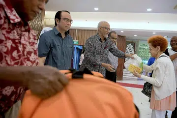 AGIH BANTUAN: Encik Mohamed Abdullah Alhabshee (tiga dari kiri), yang merupakan suami Presiden Halimah Yacob, mengagihkan barang makanan kepada penerima bantuan Jamiyah Singapura pada hujung minggu lalu. Beliau turut disertai presiden Jamiyah, Dr Mohd Hasbi Abu Bakar (dua dari kiri). - Foto BH oleh NG SOR LUAN