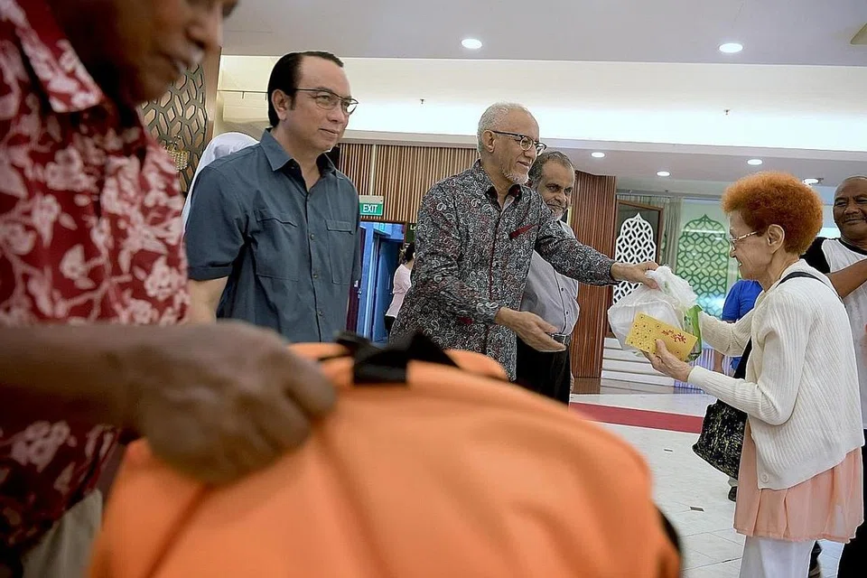 AGIH BANTUAN: Encik Mohamed Abdullah Alhabshee (tiga dari kiri), yang merupakan suami Presiden Halimah Yacob, mengagihkan barang makanan kepada penerima bantuan Jamiyah Singapura pada hujung minggu lalu. Beliau turut disertai presiden Jamiyah, Dr Mohd Hasbi Abu Bakar (dua dari kiri). - Foto BH oleh NG SOR LUAN