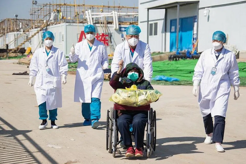 SUDAH PULIH: Seorang pesakit berusia 83 tahun (berkerusi roda) yang sudah pulih keluar dari sebuah hospital sementara untuk pesakit koronavirus di Wuhan pada 18 Februari lalu. 