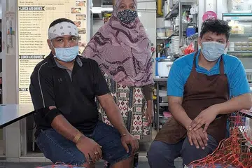 SEDIA BERTAHAN: Setelah tutup gerai makan di Institut Teknologi Singapura (SIT) disebabkan perniagaan yang lembap dek Covid-19, Encik Mohd Adillah Kamsan (kiri) dan rakan-rakan niaganya kini memberi tumpuan kepada gerai Tasty'J Western and Mediterranean Cuisine mereka di Pusat Makanan Amoy Street pula, yang baru saja dibuka pada hujung Mac lalu. - Foto BM oleh GAVIN FOO