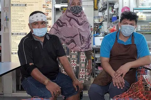 SEDIA BERTAHAN: Setelah tutup gerai makan di Institut Teknologi Singapura (SIT) disebabkan perniagaan yang lembap dek Covid-19, Encik Mohd Adillah Kamsan (kiri) dan rakan-rakan niaganya kini memberi tumpuan kepada gerai Tasty'J Western and Mediterranean Cuisine mereka di Pusat Makanan Amoy Street pula, yang baru saja dibuka pada hujung Mac lalu. - Foto BM oleh GAVIN FOO
