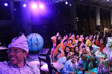 BERGAMBAR BERSAMA: Dr Maliki Osman (kiri) yang 'berselfie' dengan kumpulan dikir barat di atas pentas, turut menyertai persembahan kumpulan itu dalam satu segmen pesta Gala-Laga di WGS kelmarin. - Foto WGS 