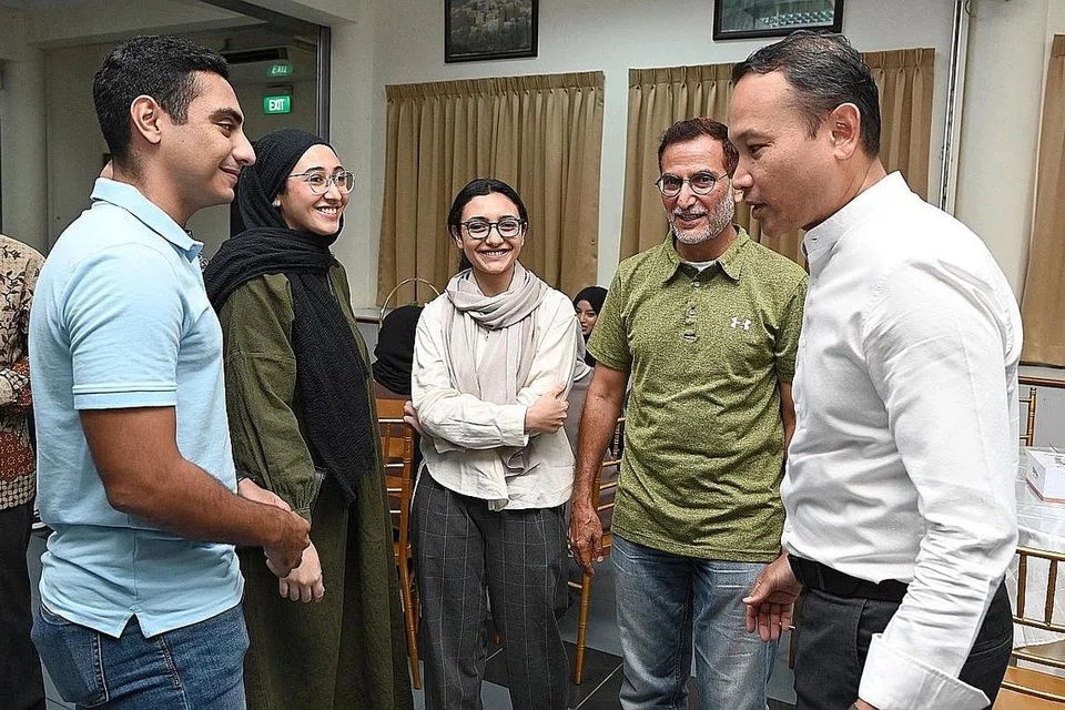 SOKONG PELAJAR: Encik Fahmi (kanan) berinteraksi dengan para penerima dermasiswa Al Wehdah dan keluarga mereka di majlis penyampaian Anugerah Dermasiswa Al Wehdah semalam. - Foto BH oleh KHALID BABA