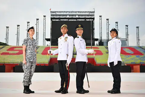 Komander Perbarisan bagi Perbarisan Hari Kebangsaan (NDP) 2025, Leftenan Kolonel (LTC) Mohamed Firdaus Ghazali, (dua dari kiri) bersama Komander kontinjen Kawalan Kehormatan Pasukan Pertahanan Awam Singapura (SCDF) Mejar Lee En Hao (dua dari kanan). Bersama mereka adalah Sukarelawan Tiga Kor Relawan Angkatan Bersenjata Singapura (SAFVC) Pang Xuehui, Arlene (kiri) dan anggota kontinjen SCDF, Sarjan Tiga Thenmoli Silvadorie.