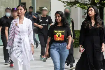 Tiga tertuduh, (dari kiri) Siti Amirah Mohamed Asrori, Annamalai Kokila Parvathi dan Mossammad Sobikun Nahar, tiba di Mahkamah  pada 27 Jun untuk menjawab tuduhan mengadakan bantahan di hadapan Istana bagi menyokong perjuangan Palestin.