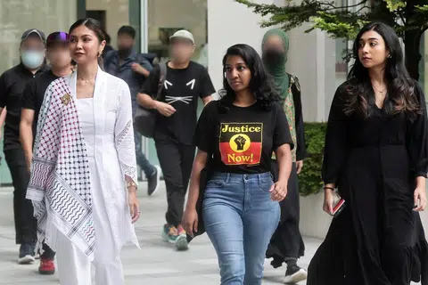 Tiga tertuduh, (dari kiri) Siti Amirah Mohamed Asrori, Annamalai Kokila Parvathi dan Mossammad Sobikun Nahar, tiba di Mahkamah  pada 27 Jun untuk menjawab tuduhan mengadakan bantahan di hadapan Istana bagi menyokong perjuangan Palestin.