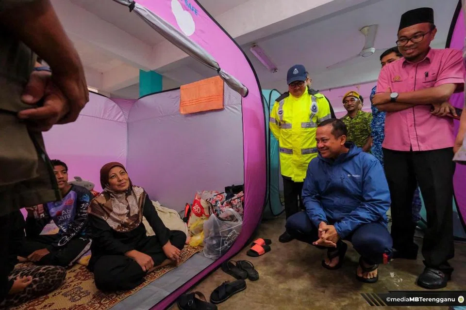 TANYA KHABAR: Menteri Besar Terengganu, Datuk Seri Dr Ahmad Samsuri Mokhtar (berbaju biru), menyantuni mangsa banjir di pusat pemindahan sementara Sekolah Kebangsaan Chendering di Kuala Terengganu, Terengganu pada Selasa.