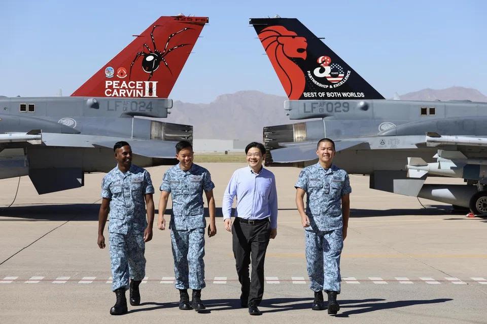 USAHA KERJASAMA: Timbalan Perdana Menteri, Encik Lawrence Wong (dua dari kanan), yang melawat detasmen Peace Carvin II RSAF di Pangkalan Tentera Udara Luke di Arizona, Amerika, menyaksikan pesawat F-16 RSAF yang ditempatkan di situ.