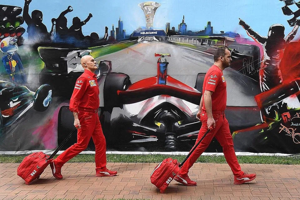KEKELIRUAN: Anggota pasukan Ferrari tiba untuk mengemaskan peralatan mereka selepas Grand Prix Formula Satu Australia dibatalkan beberapa jam sebelum sesi latihan pertama. - Foto AFP