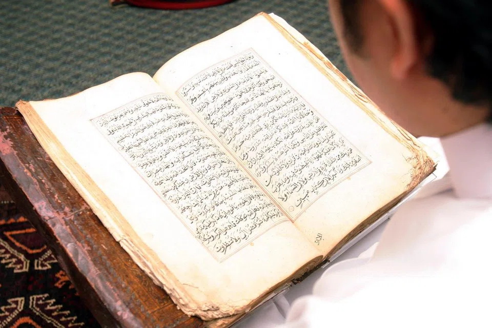 TARTIL: Seorang muslim sendang membaca Al Quran.