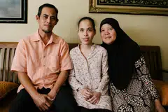TERANG HATI: Walau mata kiri buta sepenuhnya dan mata kanan pula sekadar melihat cahaya dan bayangan, namun, Cik Siti Sakinah, bekas pelajar Politeknik Nanyang (NYP), tetap berjaya memperolehi Gred Purata Mata (GPA) 3.42 bagi Diploma dalam Pengurusan Perniagaan selain Gred 6 bagi piano. Belliau diapit ibu bapanya, Encik Zainal Osman dan Cik Rubiah Ghazali. - Foto BH oleh ALVIN HO