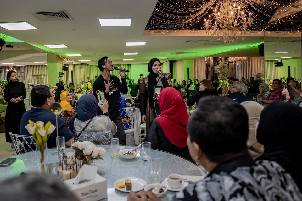 Siti Nordiana berduet dengan salah seorang penonton bagi lagu, ‘Gurauan Berkasih’. Penonton beramai-ramai menyanyikan lagu malar segar itu sambil bergilir-gilir memegang mikrofon bak satu sesi karaoke.