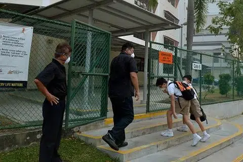 DATANG JUGA: Dua murid tiba di Sekolah Kong Hwa meskipun sekolah ditutup. Mereka menyertai pusat jagaan pelajar (SCC) di sekolah itu. - Foto THE STRAITS TIMES