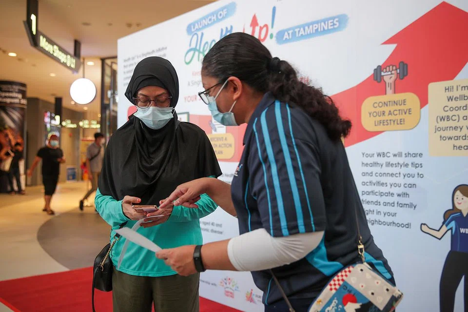 DAFTAR PROGRAM KESIHATAN: Cik Norela Mohammad, (kiri) ingin tahu lebih akan program 'Health Up!' anjuran SingHealth yang dilancarkan di Our Tampines Hub semalam. Bersama beliau ialah penyelaras kesihatan dari SingHealth, Cik Juliah Bee Abdul Latif, yang sedang menerangkan dengan lebih lanjut akan program tersebut. - Foto BM oleh GIN TAY