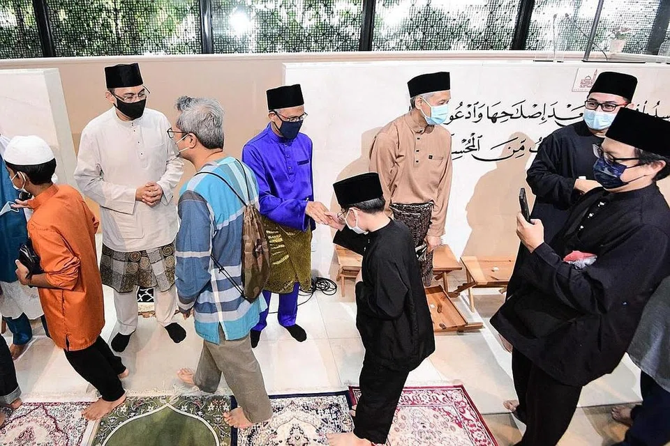 PERKUKUH CIRI GEMILANG: Encik Masagos (tengah) bersalaman dengan jemaah selepas solat Hari Raya Aidilfitri lalu. Beliau bangga masyarakat Melayu/Islam semakin berdaya tahan, prihatin dan bantu-membantu dalam mengharungi pandemik Covid-19. - Foto fail.