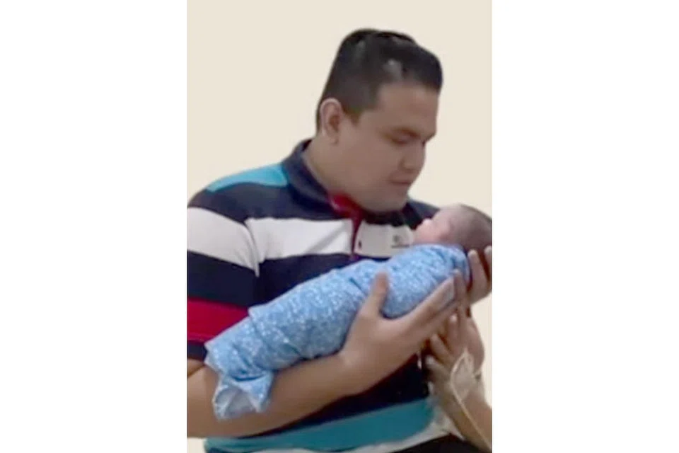 ANAK SYURGA: Azmi menimang Khairul Afnan, yang meninggal dunia kelmarin, tiga hari selepas dilahirkan. - Foto AZMI SAAT/INSTAGRAM