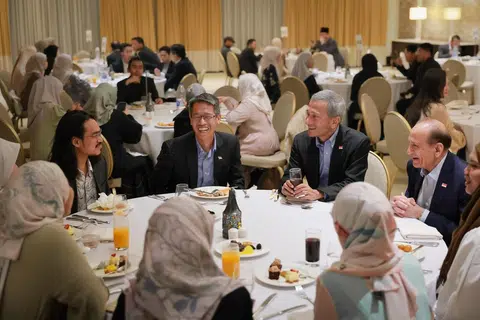 Menteri Ehwal Luar Singapura, Dr Vivian Balakrishnan, bersama Anggota Parlimen Parti Pekerja (WP) Encik Gerald Giam (kanan beliau) dan Duta Bukan Pemastautin Singapura ke Jordan, Encik Shamsher Zaman (kiri beliau), bercakap dengan pelajar Singapura di Amman, Jordan, di majlis iftar pada 17 Mac. 