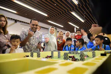 SERONOK MENCUBA: Anggota Parlimen GRC Chua Chu Kang, Encik Zhulkarnain Abdul Rahim (dua dari kiri) dan Setiausaha Parlimen Kanan (Kesihatan merangkap Undang-undang), Cik Rahayu Mahzam (tiga dari kiri)  menyertai kanak-kanak yang mencuba kegiatan di Trek Lumba dan Balapan Berhalang di acara Raikan Ilmu@Heartlands (Jurong East) di IMM pada Sabtu.