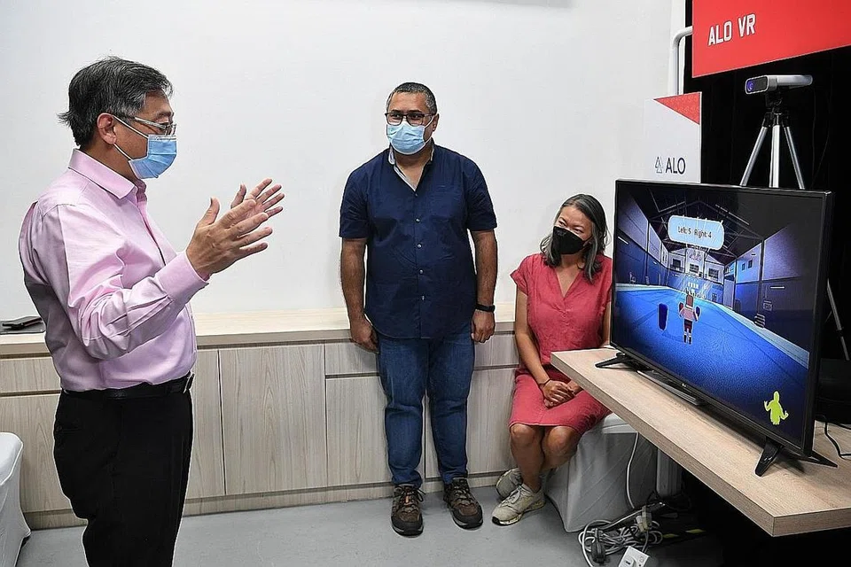 MANFAATKAN HUBUNGAN: Encik Gan Kim Yong (kiri) sedang mencuba alat kecergasan, Vigour Smart Fitness yang merupakan sistem realiti lanjutan oleh syarikat ALO VR. Beliau ditemani pengasas bersama Encik Amit Virmani dan Cik Seah Kui Luan semasa pelancaran Link semalam. - Foto BH oleh CHONG JUN LIANG