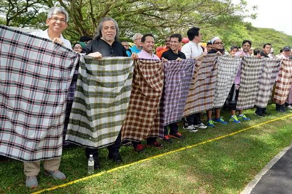 CIPTA REKOD KAIN SARUNG TERPANJANG: (Dari kiri) Dr Yaacob Ibrahim, 'Papa Rok' Datuk Ramli Sarip; Pengerusi Masjid Sallim Mattar, Encik Muhammad Fauzi Ali; dan Presiden Muis, Haji Alami Musa antara peserta yang menyertai ikatan kain sarung terpanjang yang dimasukkan ke dalam Buku Rekod Guinness Singapura. - Foto M.O. SALLEH