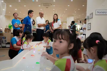 Presiden Tharman Shanmugaratnam (berdiri, tiga dari kiri) dan Setiausaha Parlimen Kanan (Kebudayaan, Masyarakat dan Belia merangkap Pembangunan Sosial dan Keluarga), Encik Eric Chua (dua dari kiri), melawat tadika M.Y World @ Dawson untuk sambutan Hari Guru di tadika itu pada 29 Ogos. 