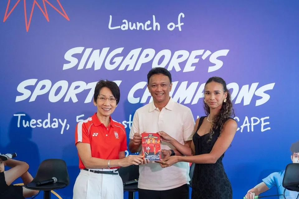 Legenda bola sepak tempatan, Fandi Ahmad (tengah), menerima buku sukan kanak-kanak terkini, ‘Singapore’s Sports Champions’, daripada Menteri Kemampanan dan Sekitaran yang juga presiden Majlis Olimpik Kebangsaan Singapura (Snoc), Cik Grace Fu (kiri), di majlis pelancaran buku itu di Scape, Orchard pada 5 Ogos. Beliau ditemani anak perempuannya, Iman Fandi. 