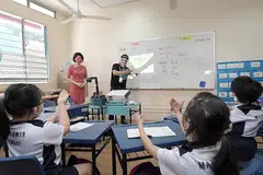 SOKONGAN KHUSUS: Dalam lawatannya ke Sekolah Rendah Mayflower semalam, Cik Sun Xueling (baju merah jambu) mengumumkan kanak-kanak yang mengalami kehilangan pendengaran akan mendapat sokongan khusus dalam bahasa isyarat buat kali pertama di prasekolah kendalian MOE di Sekolah Rendah Mayflower mulai 2022. - Foto BH oleh ALPHONSUS CHERN