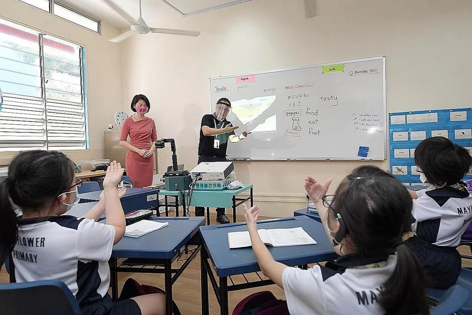 SOKONGAN KHUSUS: Dalam lawatannya ke Sekolah Rendah Mayflower semalam, Cik Sun Xueling (baju merah jambu) mengumumkan kanak-kanak yang mengalami kehilangan pendengaran akan mendapat sokongan khusus dalam bahasa isyarat buat kali pertama di prasekolah kendalian MOE di Sekolah Rendah Mayflower mulai 2022. - Foto BH oleh ALPHONSUS CHERN