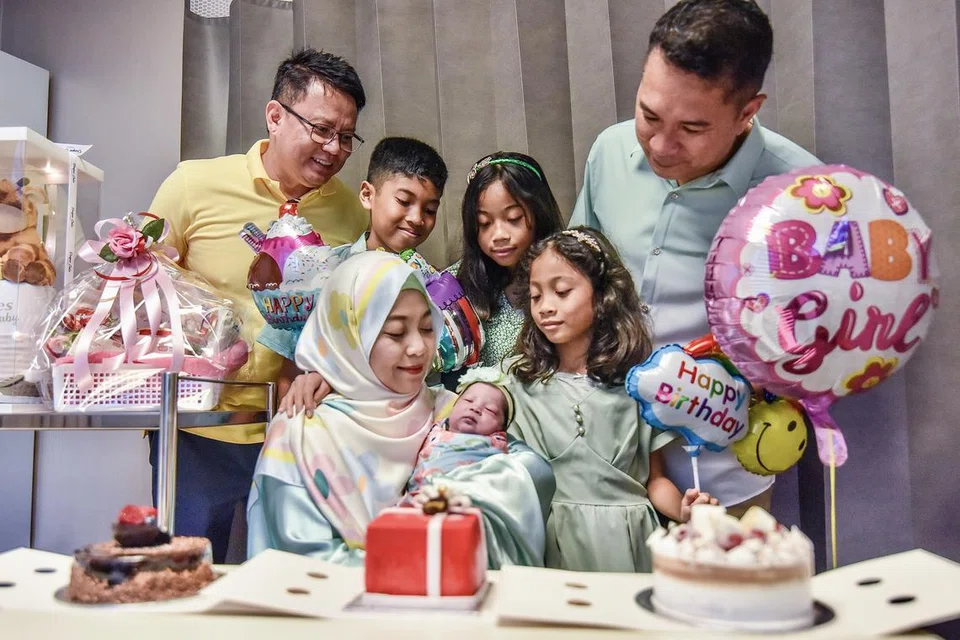 SAMBUT EMPAT HARI LAHIR SEKALI GUS: Dr Jazlan Joosoph (kiri) sama-sama meraikan hari lahir anak-anak Encik Salihin Ahmad Perbah (kanan) dan Cik Khairunnisa Abdul Karim (duduk sambil menggendong bayi).