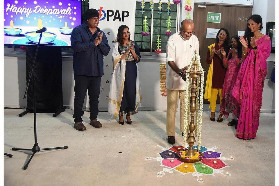 MENYALA 'RANGOLI': Encik Shanmugam menyalakan rangoli semasa pelancaran video Light Of Hope di PAP, cawangan Chong Pang. - Foto BH oleh DESMOND WEE