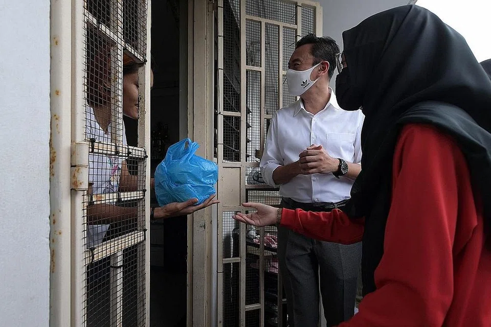 BUBUR UNTUK KUKOH: AP GRC Jalan Besar, Dr Wan Rizal Wan Zakariah, turut membantu mengedar bubur buka puasa tajaan Madrasah Aljunied kepada 100 keluarga flat sewa di Jalan Kukoh semalam, bersama pelajar madrasah itu dan relawan MKuasaTiga (M3@Jalan Besar). - Foto BH oleh ALPHONSUS CHERN